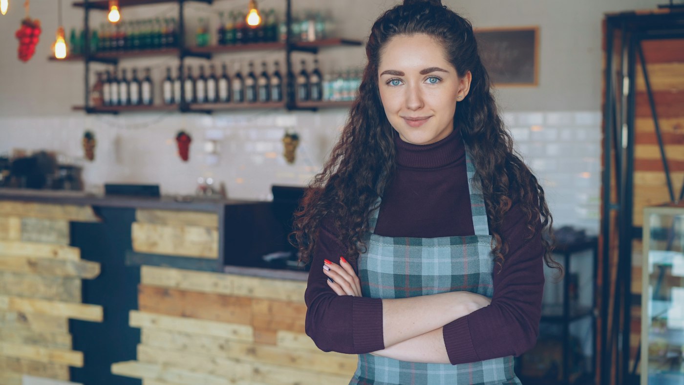 Small business owner standing in her cafe
